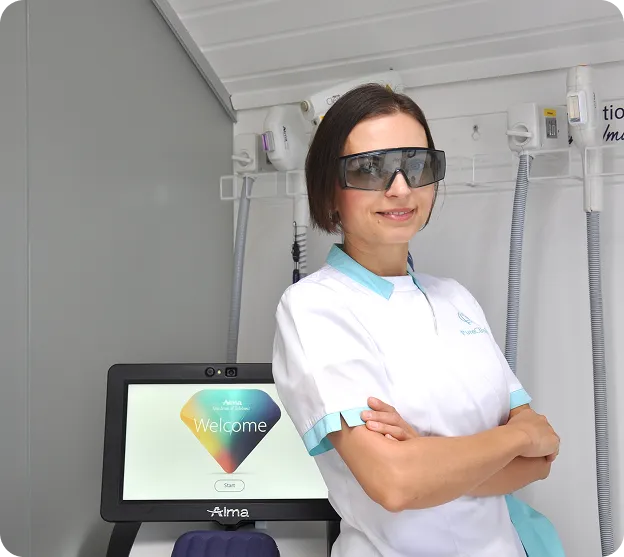 Professional aesthetic clinic specialist wearing protective laser safety glasses beside advanced skin treatment equipment.